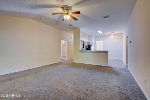 a view of a kitchen with a stove cabinets a ceiling fan and wooden floor