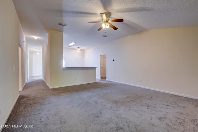 an empty room with a ceiling fan and a window