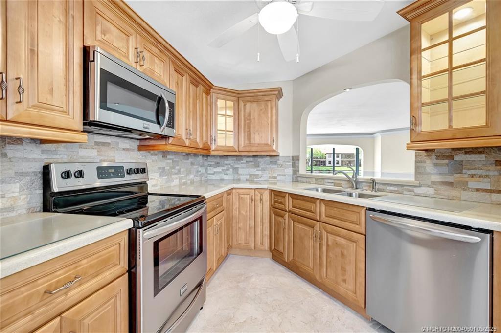 6040 Southeast Martinique Drive, Unit 102 Stuart, FL 34997 - Photo 13 of 52 a kitchen with stainless steel appliances granite countertop a stove microwave and sink