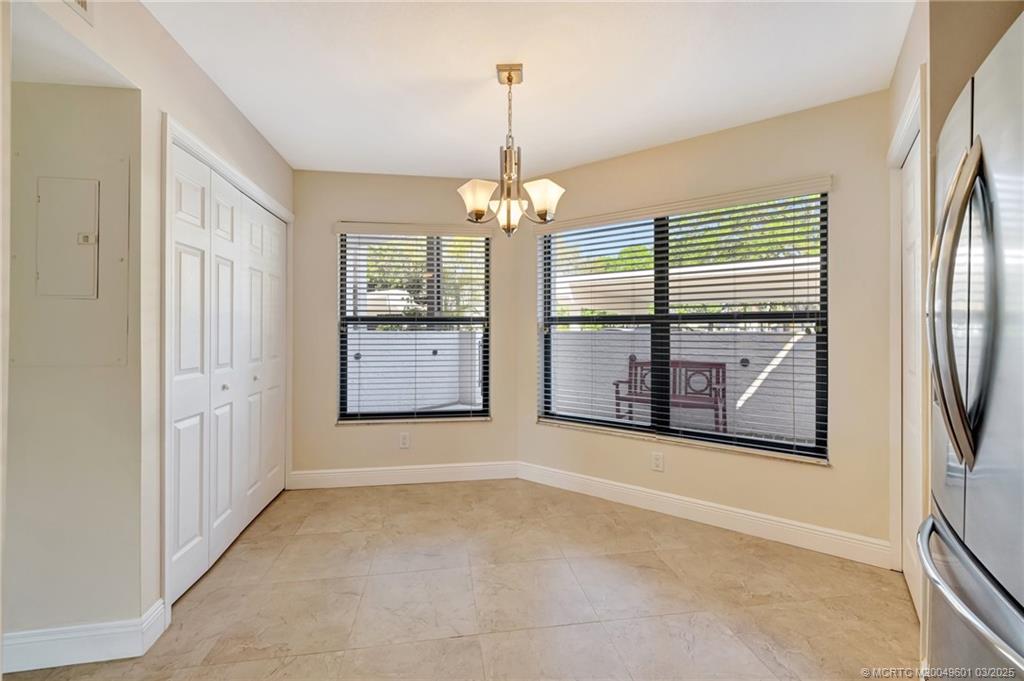 6040 Southeast Martinique Drive, Unit 102 Stuart, FL 34997 - Photo 15 of 52 an empty room with windows and fireplace