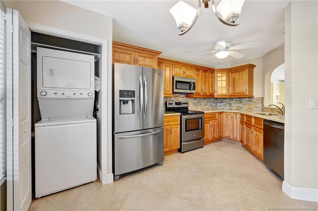 6040 Southeast Martinique Drive, Unit 102 Stuart, FL 34997 - Photo 16 of 52 a kitchen with cabinets stainless steel appliances and a window