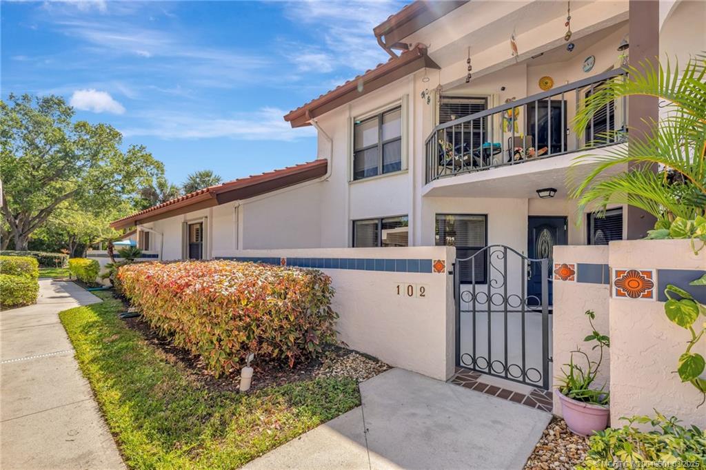 6040 Southeast Martinique Drive, Unit 102 Stuart, FL 34997 - Photo 2 of 52 front view of a house with a yard