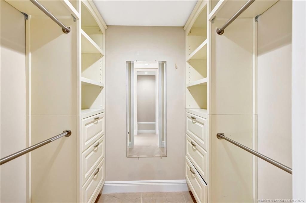 6040 Southeast Martinique Drive, Unit 102 Stuart, FL 34997 - Photo 27 of 52 a bathroom with a mirror and a glass door shower