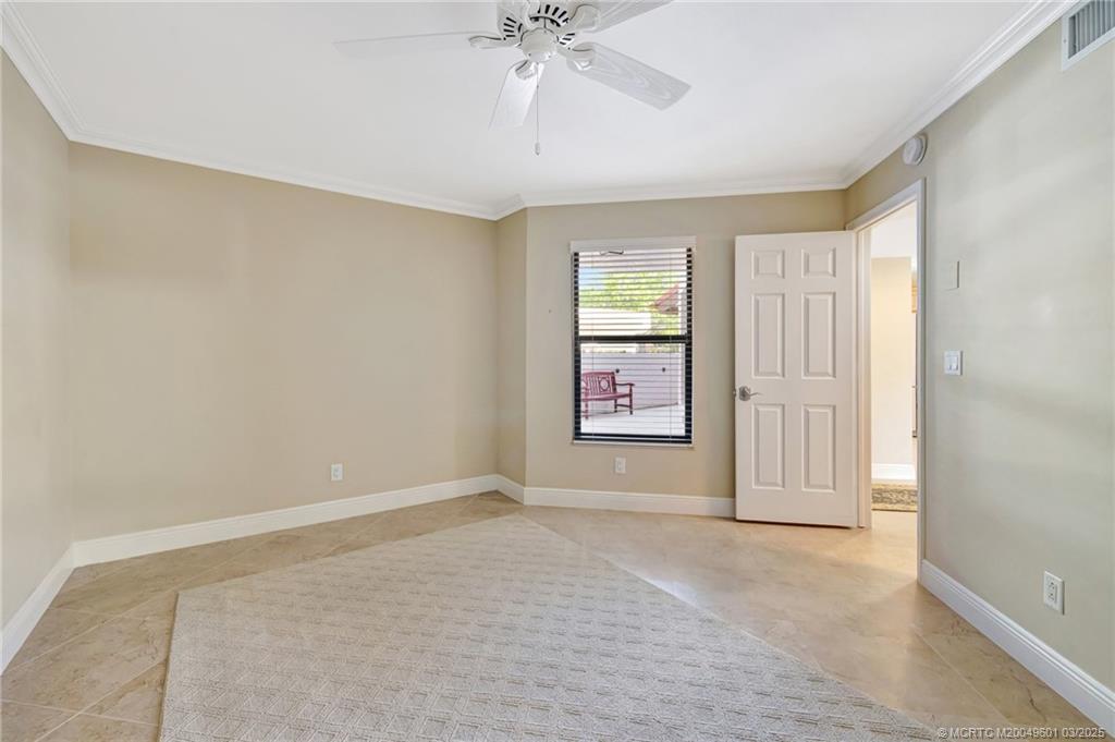 6040 Southeast Martinique Drive, Unit 102 Stuart, FL 34997 - Photo 32 of 52 an empty room with windows and fan