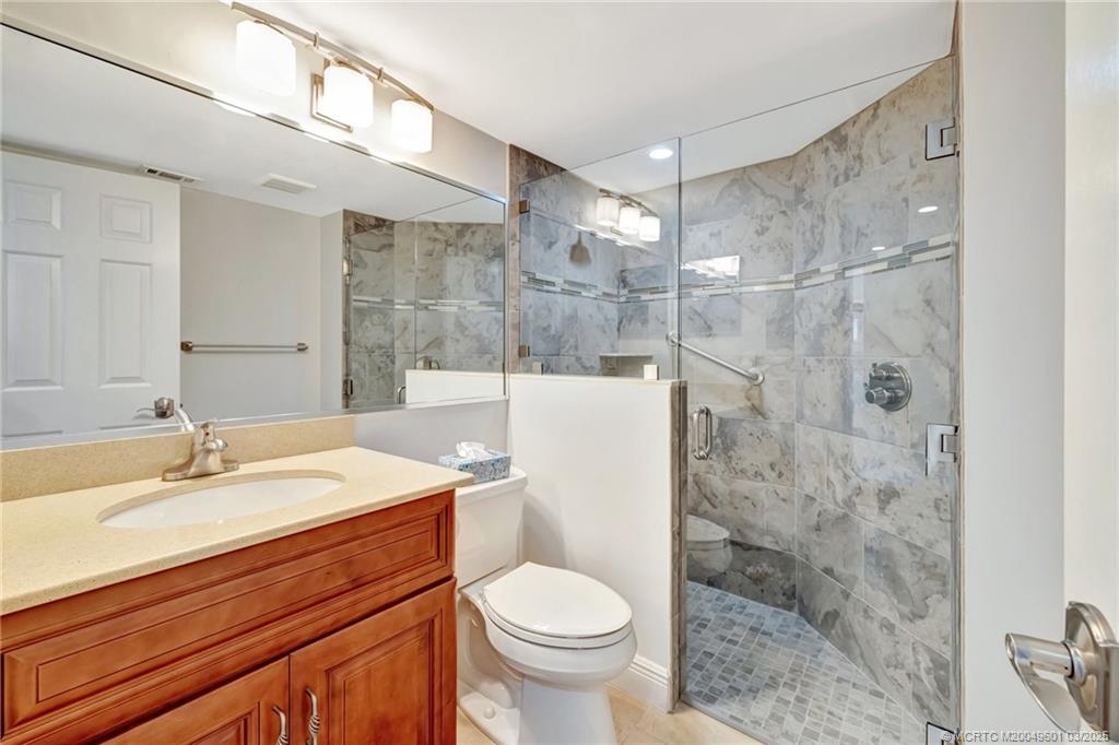 6040 Southeast Martinique Drive, Unit 102 Stuart, FL 34997 - Photo 33 of 52 a bathroom with a sink toilet and shower