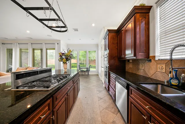a kitchen with stainless steel appliances sink stove and cabinets