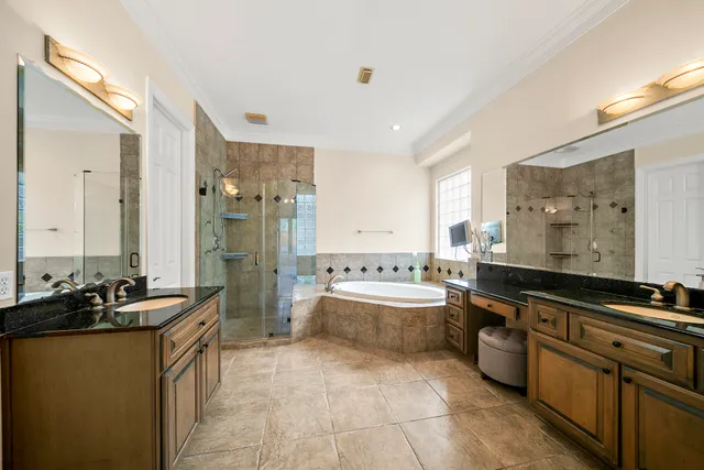 a large bathroom with a double vanity sink a large mirror and a bathtub