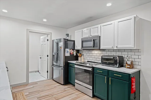 a kitchen with stainless steel appliances granite countertop a refrigerator stove and sink