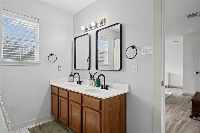 a bathroom with a double vanity sink and a mirror