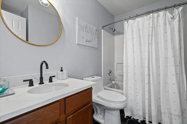 a bathroom with a sink vanity mirror and toilet