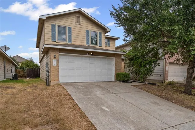 a front view of a house with a yard and garage