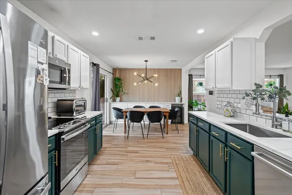 a kitchen with stainless steel appliances a stove sink microwave and cabinets