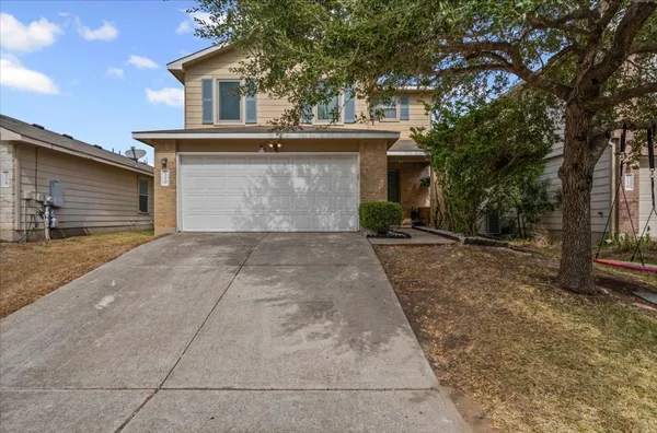a front view of a house with yard and parking