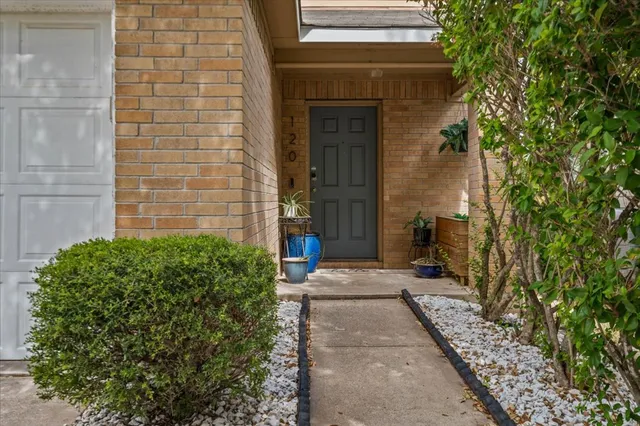 a pathway of a house with potted plants