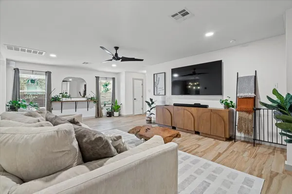 a living room with furniture flat screen tv and wooden floor