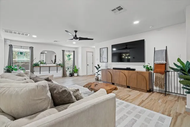 a living room with furniture flat screen tv and wooden floor