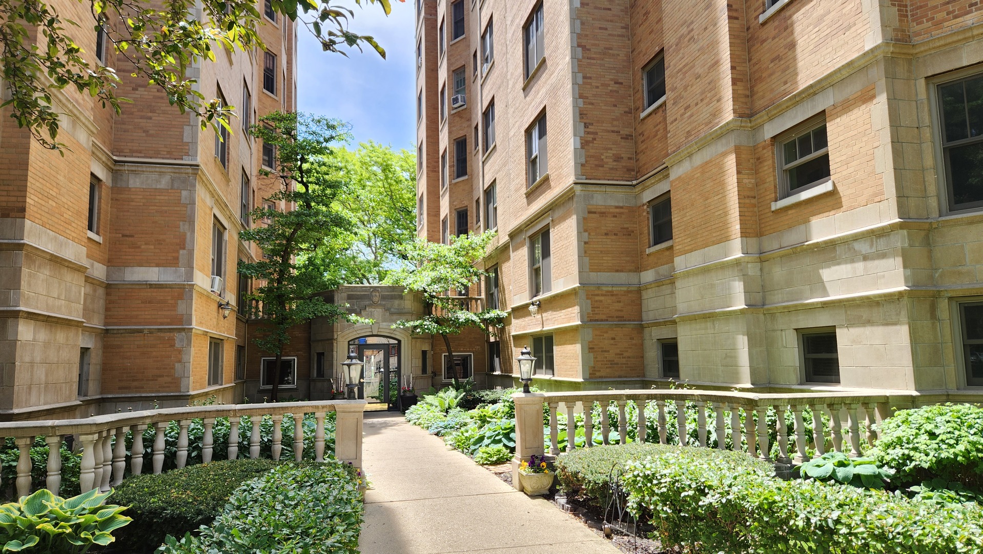 a front view of a multi story residential apartment building with a yard