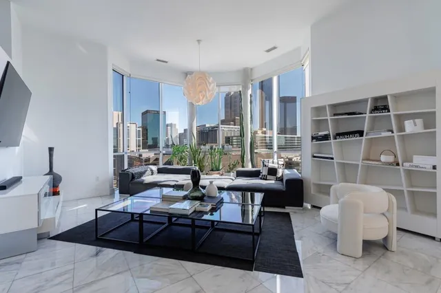 a living room with furniture a rug and a large window