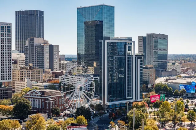 a front view of a building with streets and trees