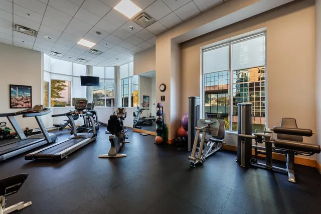 a living room with furniture gym equipment and a large window
