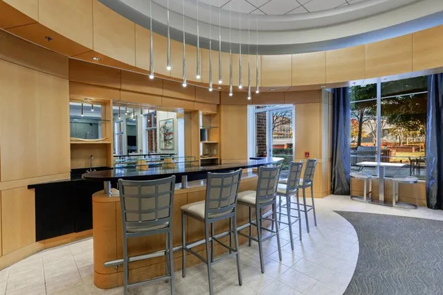 a dining hall with stainless steel appliances kitchen island granite countertop a table and chairs in it