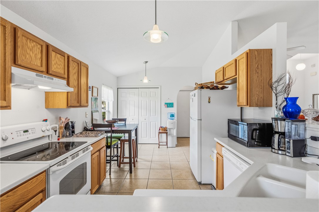 131 Bellamy Trail Sebastian, FL 32958 - Photo 11 of 32 a kitchen with stainless steel appliances kitchen island granite countertop a stove a sink a refrigerator and cabinets