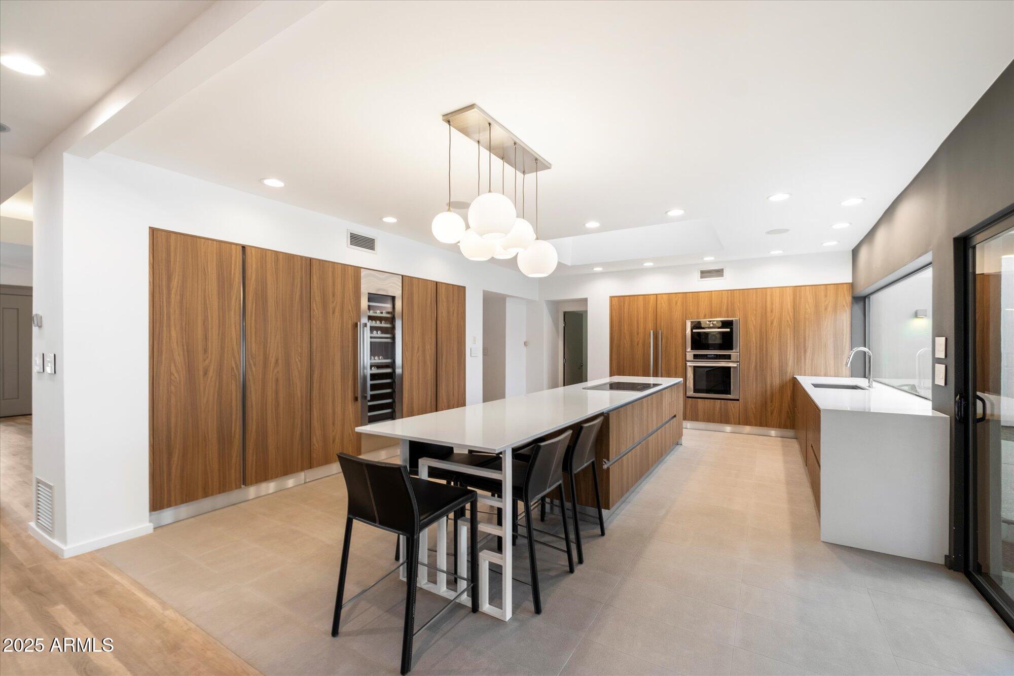 25 West Frier Drive Phoenix, AZ 85021 - Photo 13 of 43 a kitchen with stainless steel appliances kitchen island granite countertop a table chairs sink and cabinets