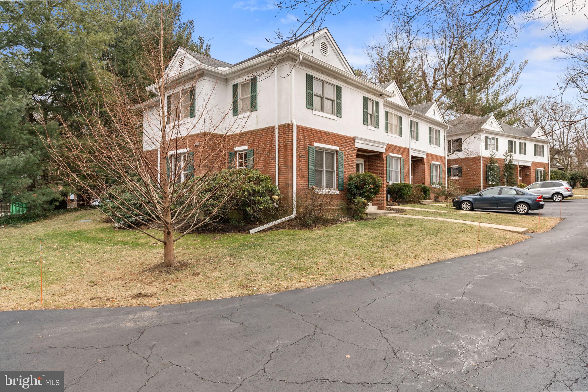 a view of a white house with a yard next to a road