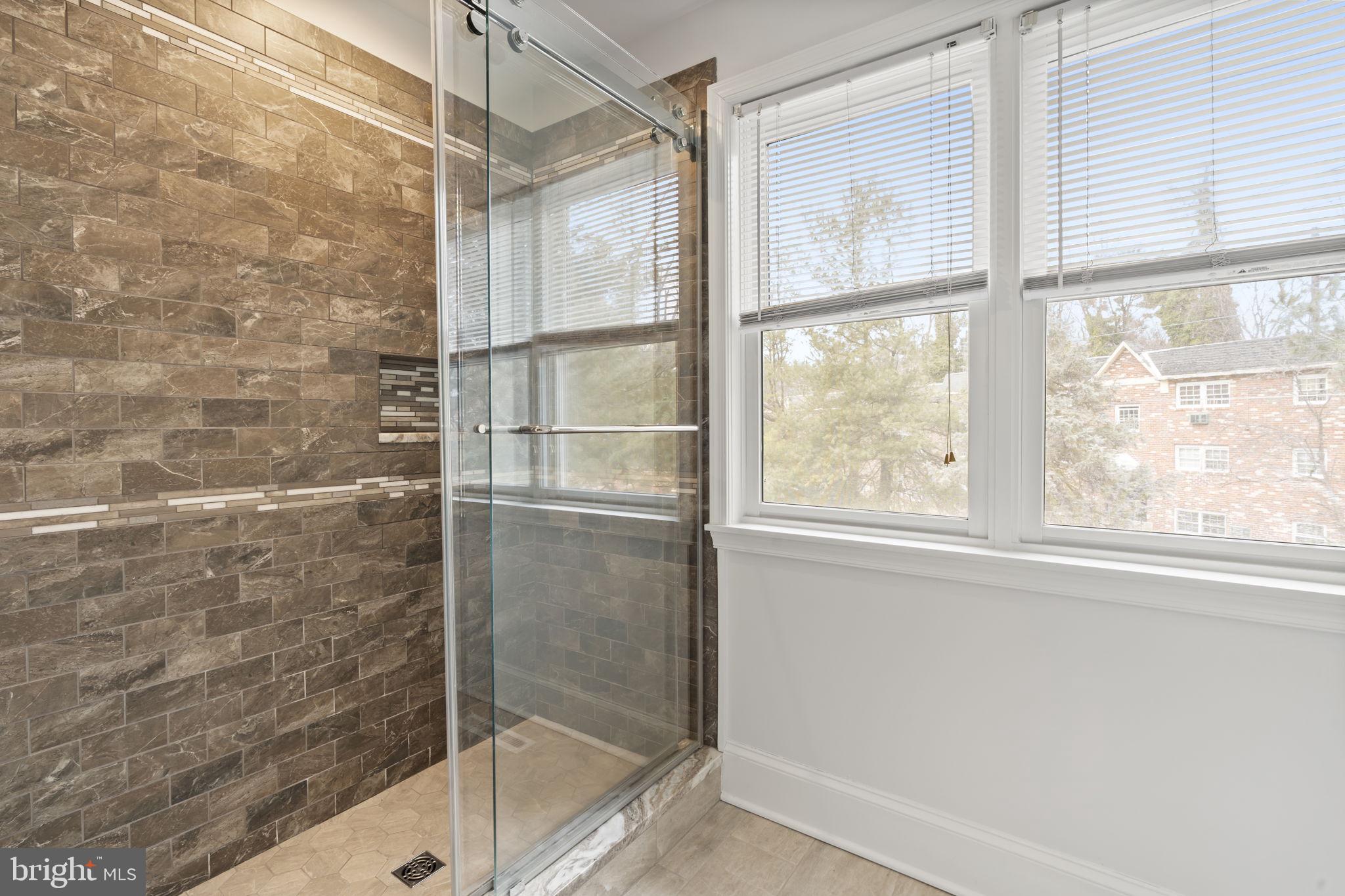 115 Roumfort Road, Unit 26 Philadelphia, PA 19119 - Photo 22 of 33 a bathroom with a glass shower door