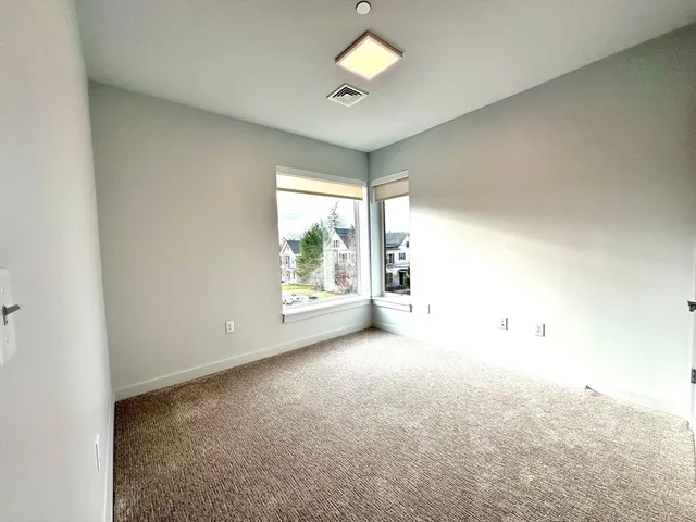 an empty room with windows and ceiling fan