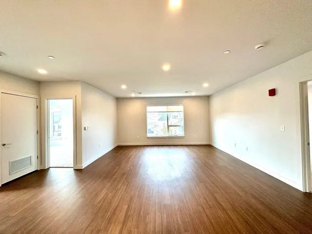 a view of an empty room with wooden floor