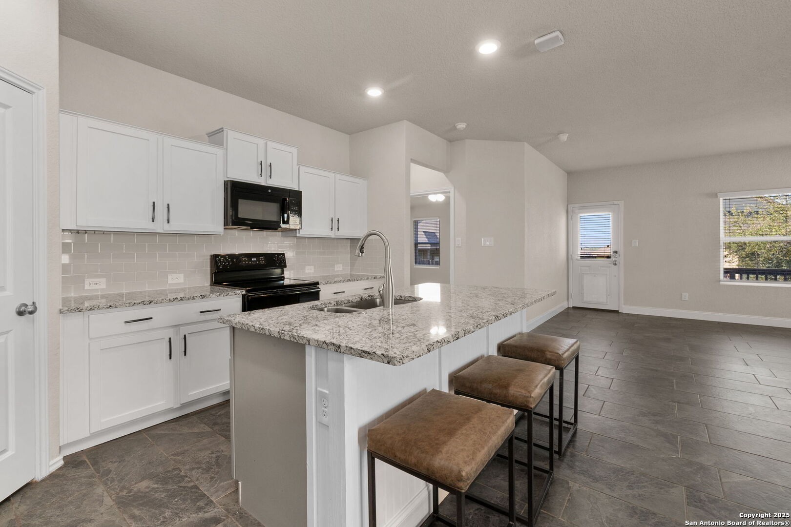 10306 Midsummer Meadow Converse, TX 78109 - Photo 12 of 20 a kitchen with stainless steel appliances granite countertop a stove a sink a microwave a refrigerator and cabinets
