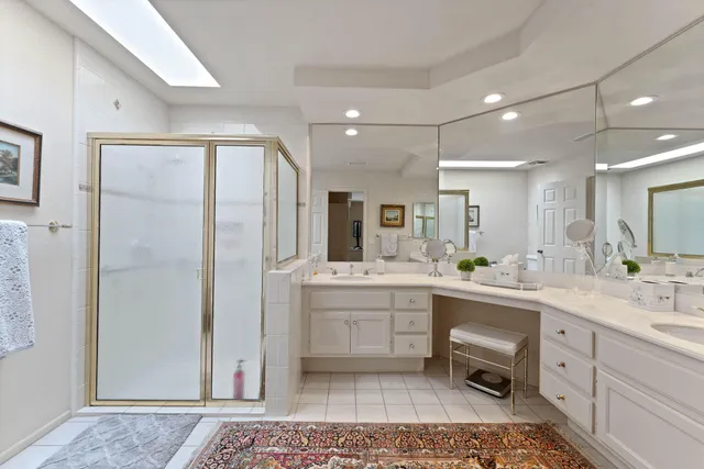 a large bathroom with a glass door shower and sink