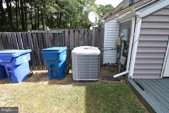 a view of a backyard with wooden fence and a large tree