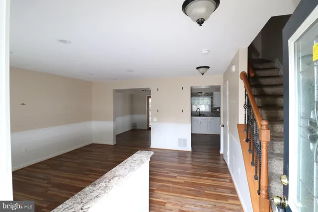 a hallway view with wooden floor and staircase