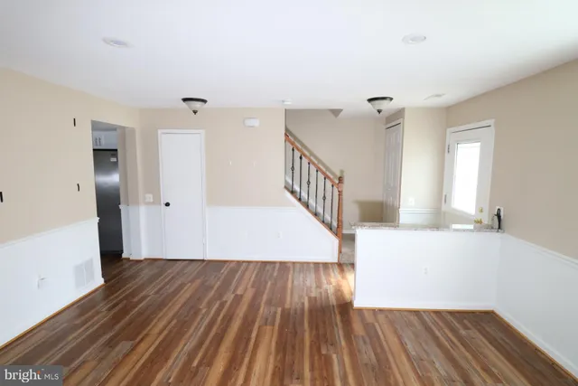 a view of a room with wooden floor and staircase