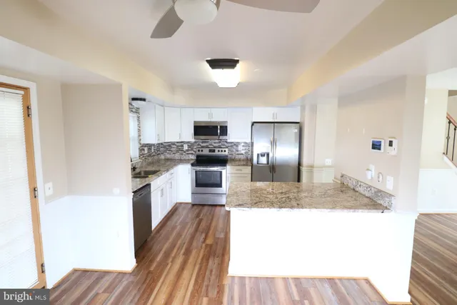 a large kitchen with a sink stainless steel appliances and cabinets