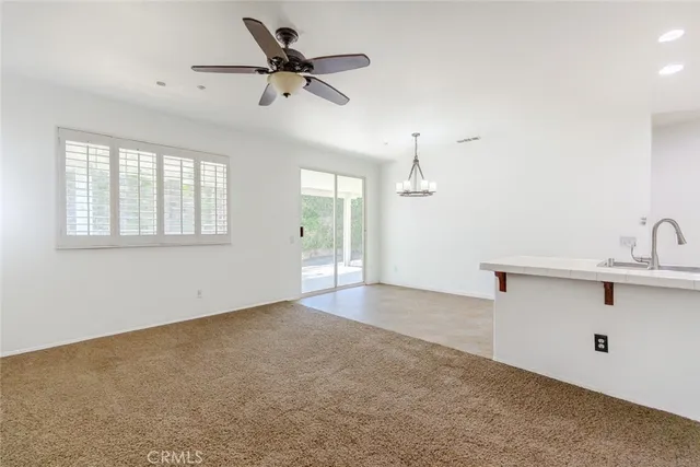 an empty room with a ceiling fan and a window