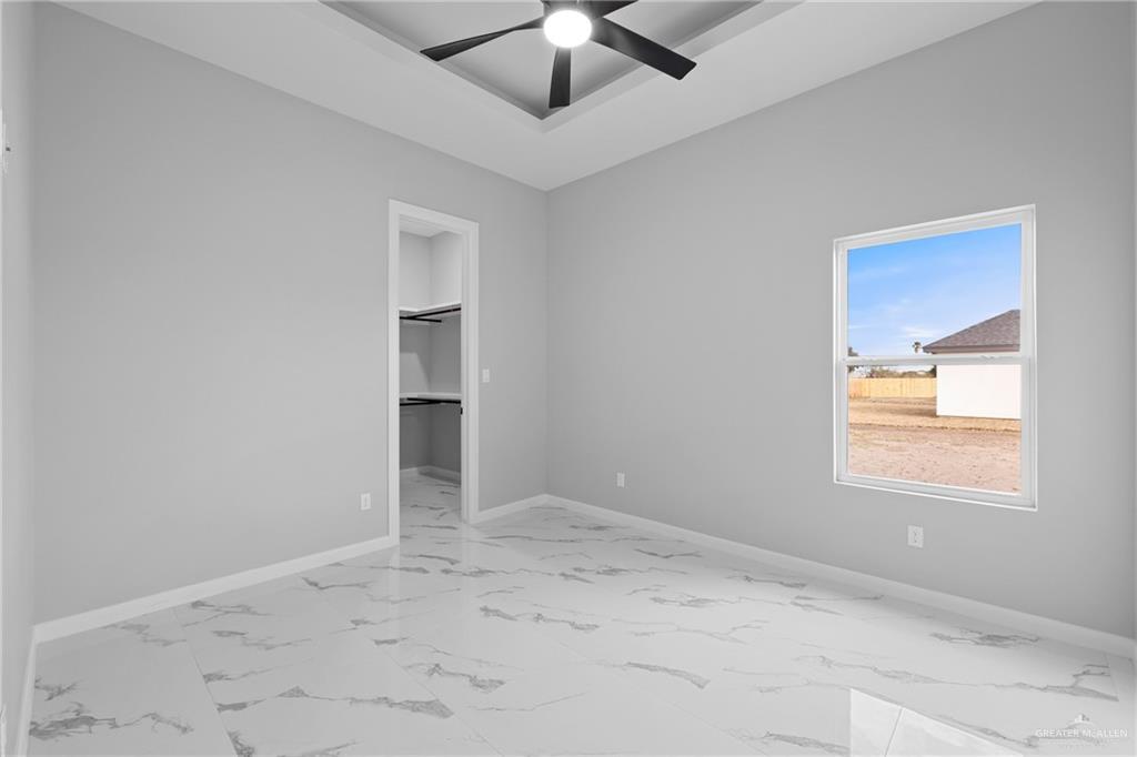 5100 Duke Avenue McAllen, TX 78504 - Photo 15 of 24 an empty room with a chandelier fan and windows