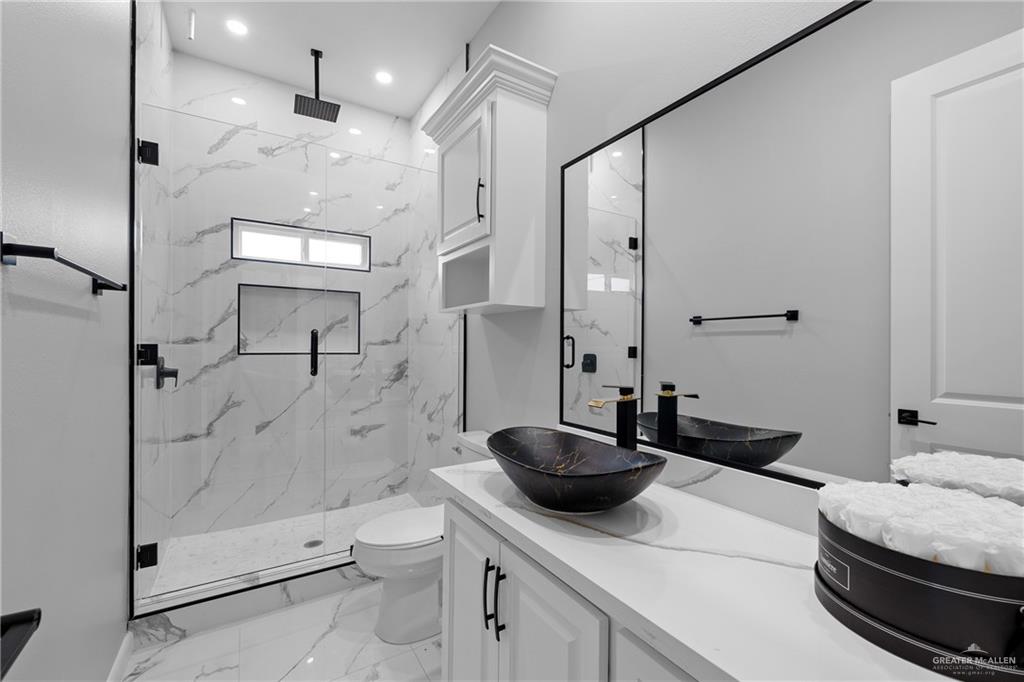 5100 Duke Avenue McAllen, TX 78504 - Photo 17 of 24 a bathroom with a double vanity sink toilet and shower