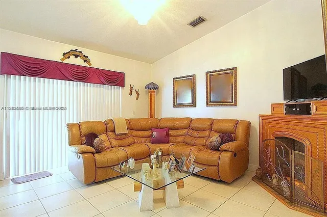a view of a livingroom and dining room with furniture wooden floor and a chandelier