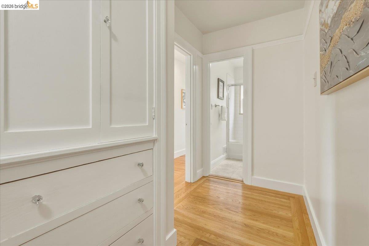 2403 Cedar Street Berkeley, CA 94708 - Photo 14 of 33 Hallway featuring built-in white cabinetry with crystal knobs, wood-finish flooring, and white baseboards