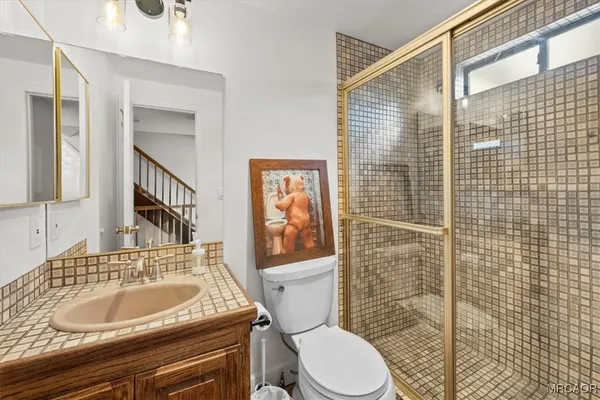 a bathroom with a sink a toilet and shower