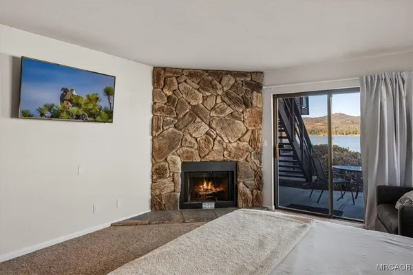 a living room with a fireplace and a floor to ceiling window