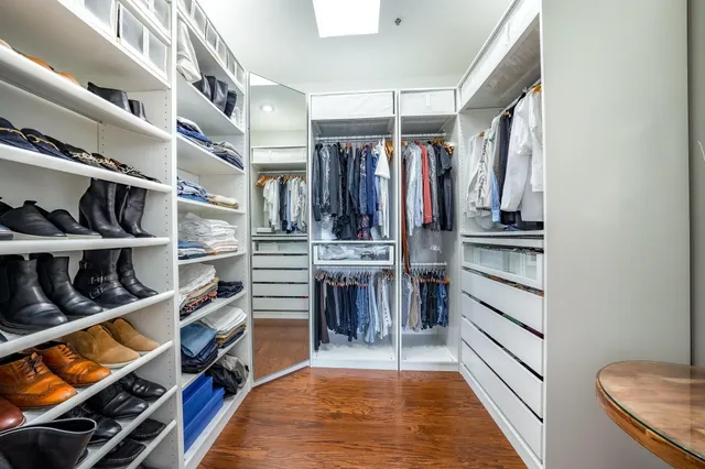 a view of walk in closet with clothes and shoes