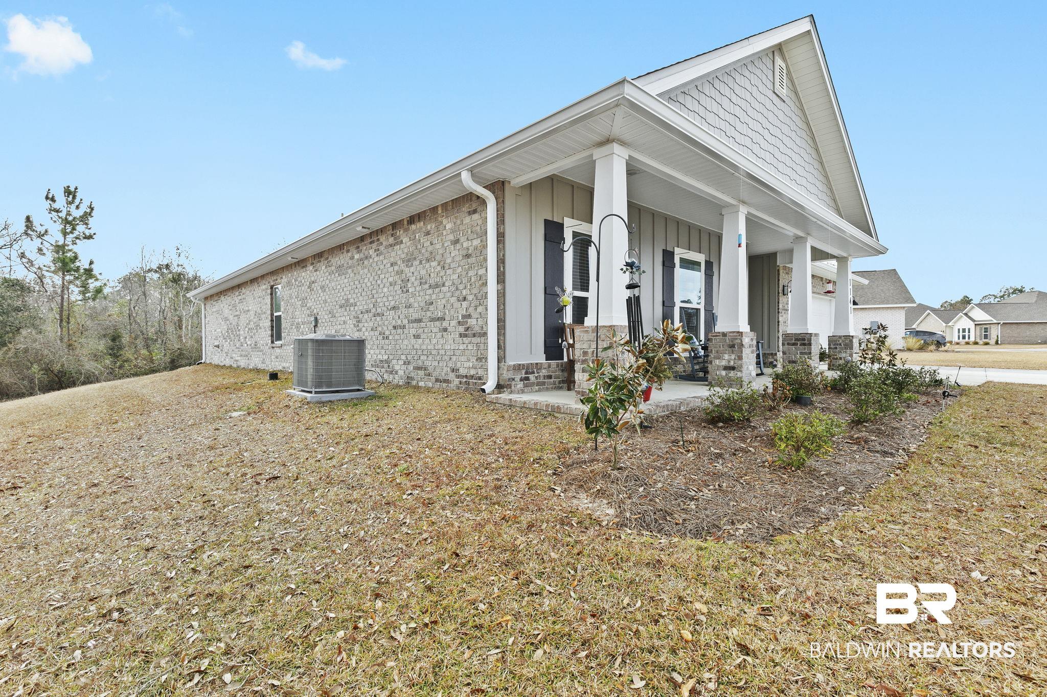 1141 Pencarro Boulevard Foley, AL 36535 - Photo 54 of 70 View of property exterior featuring cooling unit and covered porch