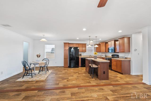 5401 Red House Road Rustburg, VA 24588 - Photo 7 of 27 a large kitchen with stainless steel appliances granite countertop a stove top oven a sink dishwasher a dining table and chairs with wooden floor