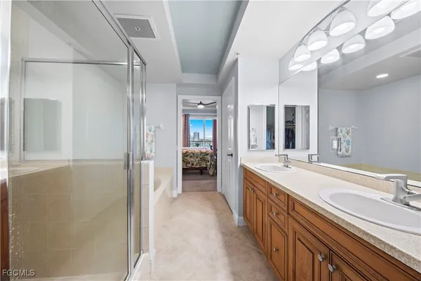a large bathroom with a double vanity sink a mirror and a shower