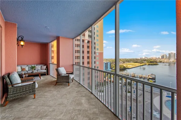 a balcony with chairs and city view