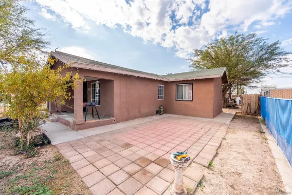 a backyard of a house with table and sofas